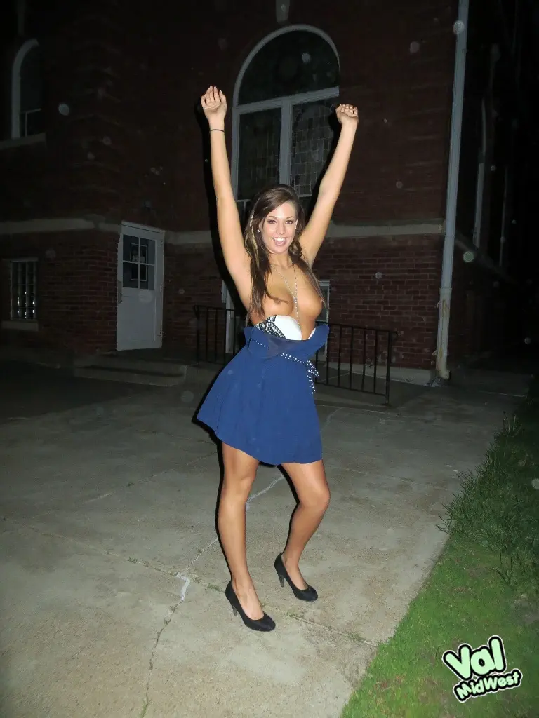 Val theWoo in a blue mini dress posing topless and lying in a garden planter at night