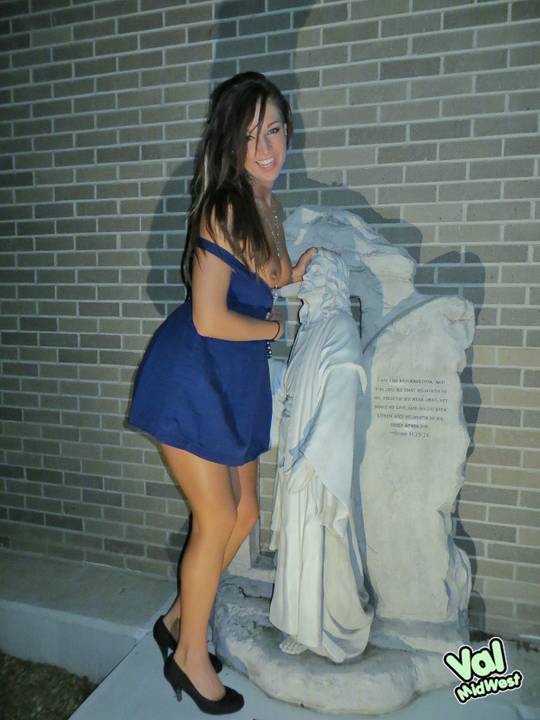 Val theWoo in a blue mini dress posing topless and lying in a garden planter at night