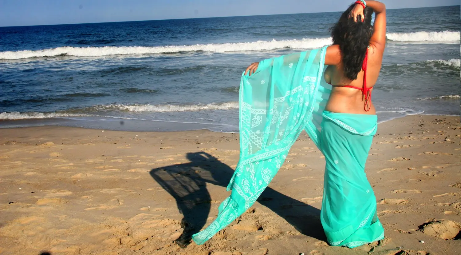Curvy Indian bhabhi in a red bikini and turquoise sarong posing on a sandy beach