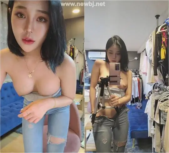 Korean BJ posing for a selfie in a bedroom, pulling up a white lace top to show her busty chest and nipples