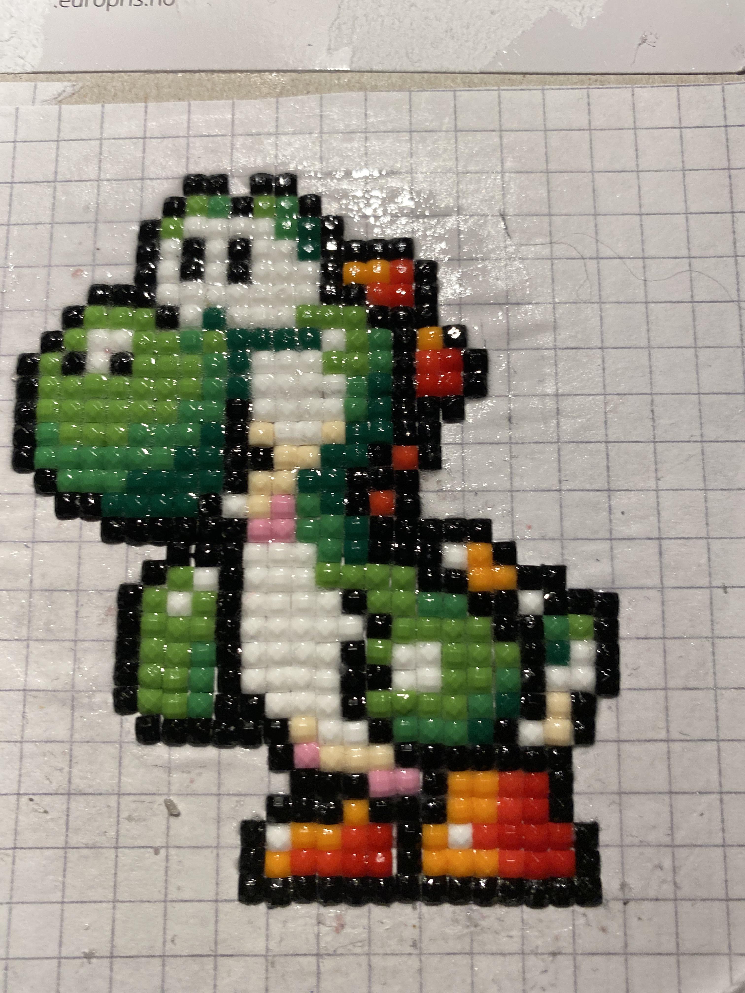 I made this 8- bit yoshi diamond painting with som left over bits i had ...