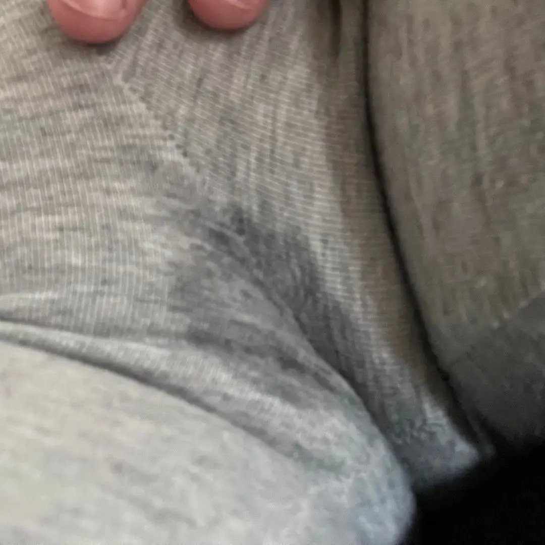 Close-up of grey sweatpants with a wet spot and pussy print from rubbing.