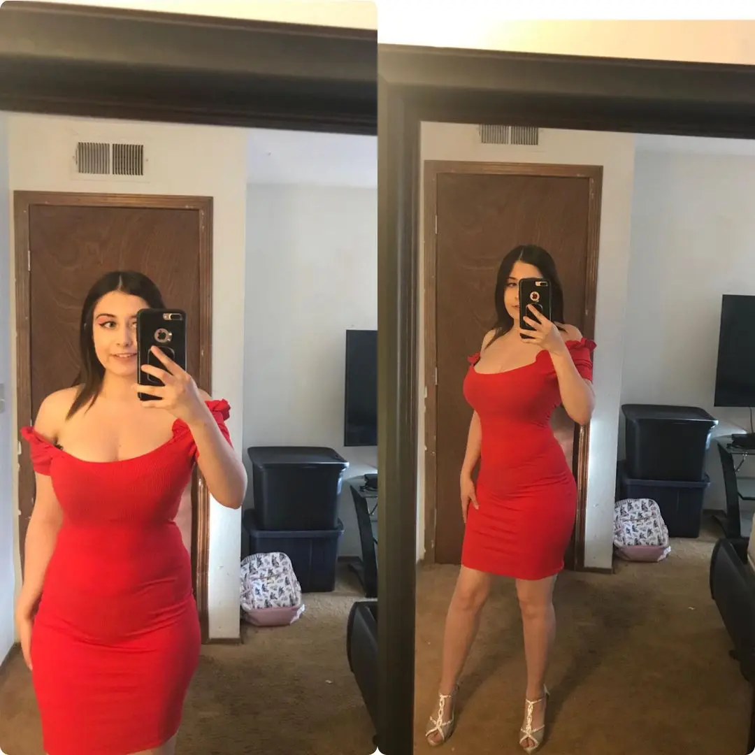 Curvy latina in a tight red off-the-shoulder mini dress and gold high heels posing for a mirror selfie