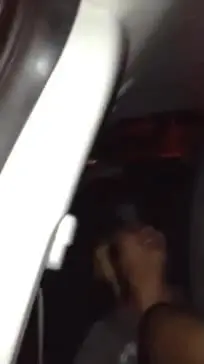 Slim blonde black woman showing her bare soles and toes in a car interior