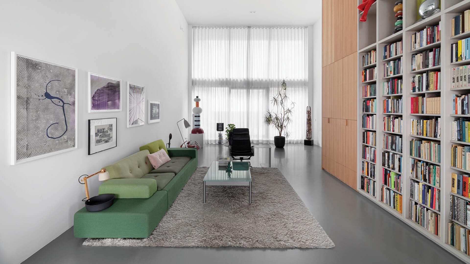 White Living room with double height bookshelf, a green couch and
