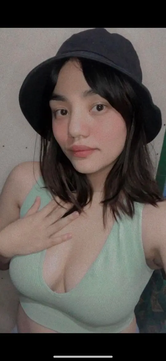 Filipina woman in a black bucket hat and light green ribbed tank top