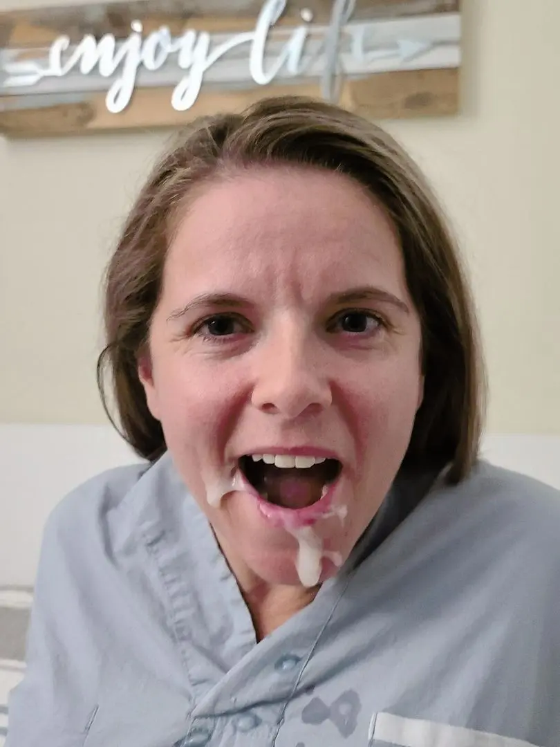 Slim brunette woman in a blue robe with a cum facial and cum in mouth selfie