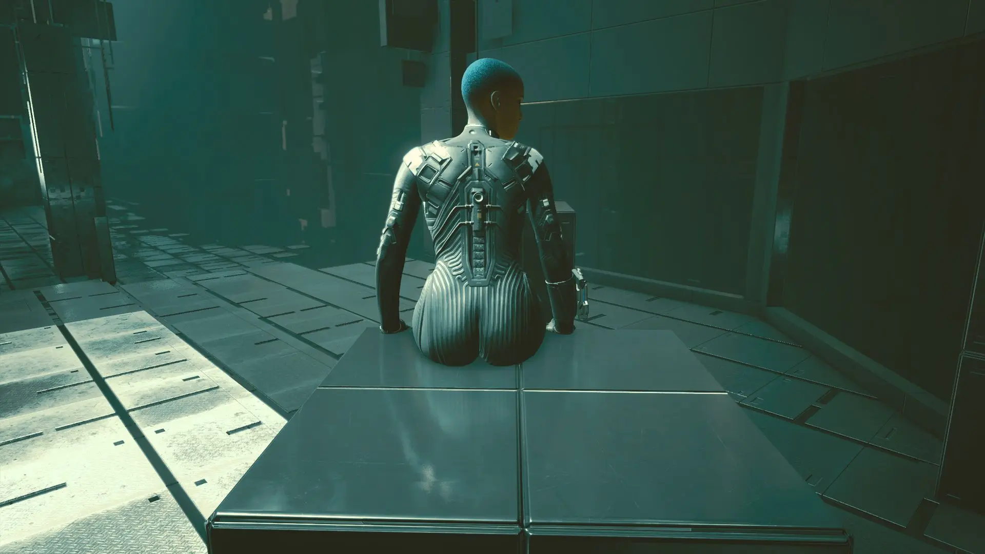 T-Bug with short blue hair wearing a black shiny catsuit bodysuit on a metallic platform in a sci-fi setting