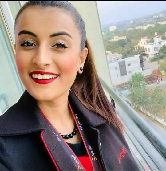 Himani Tango in a SpiceJet flight attendant uniform taking a selfie on a balcony