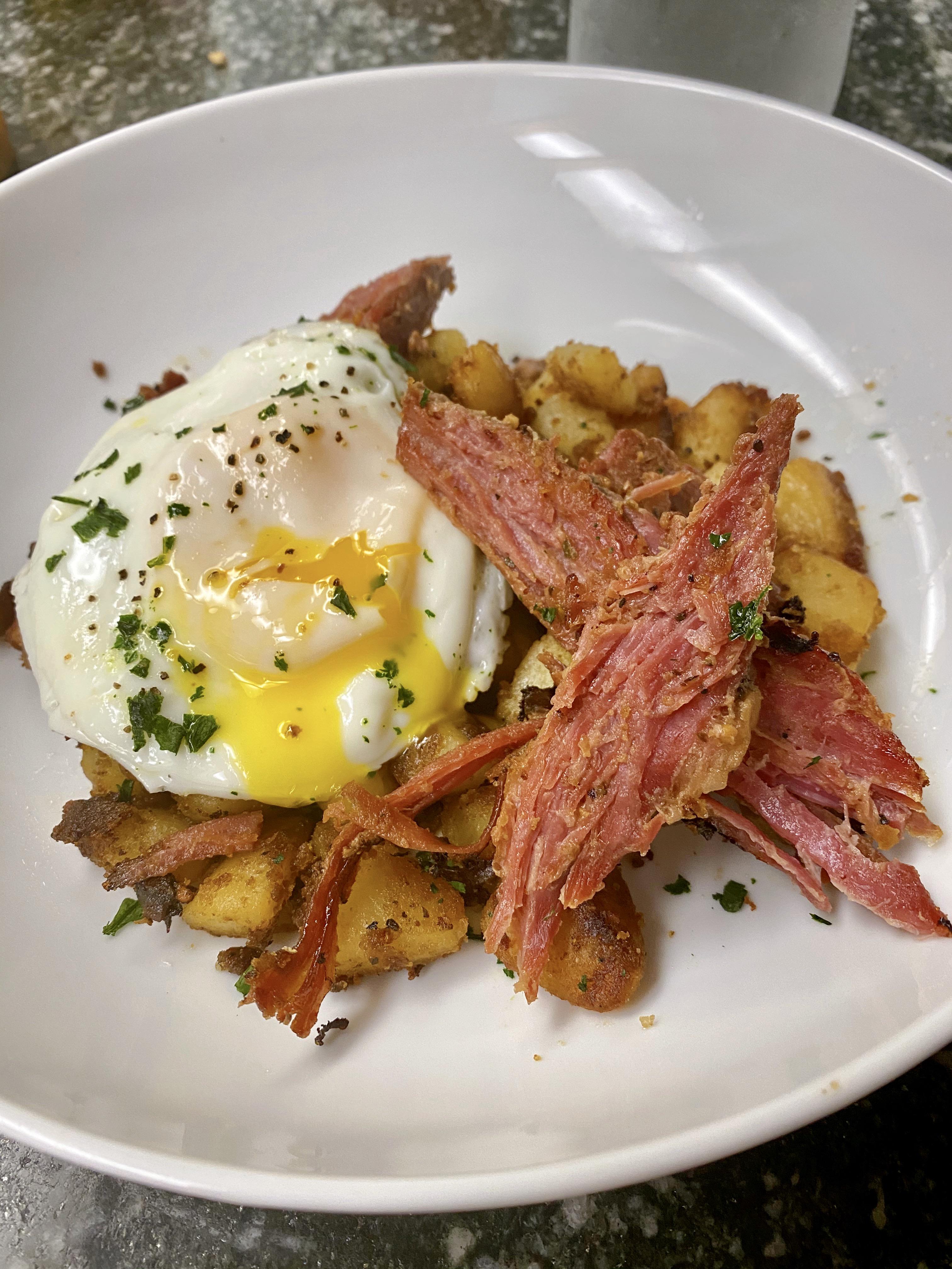 Homemade Corned beef brisket over breakfast potatoes and runny steamed