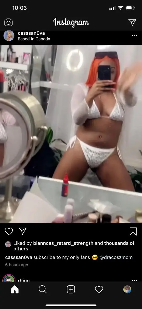 Casssanova in a white lace bikini and sheer top taking a mirror selfie