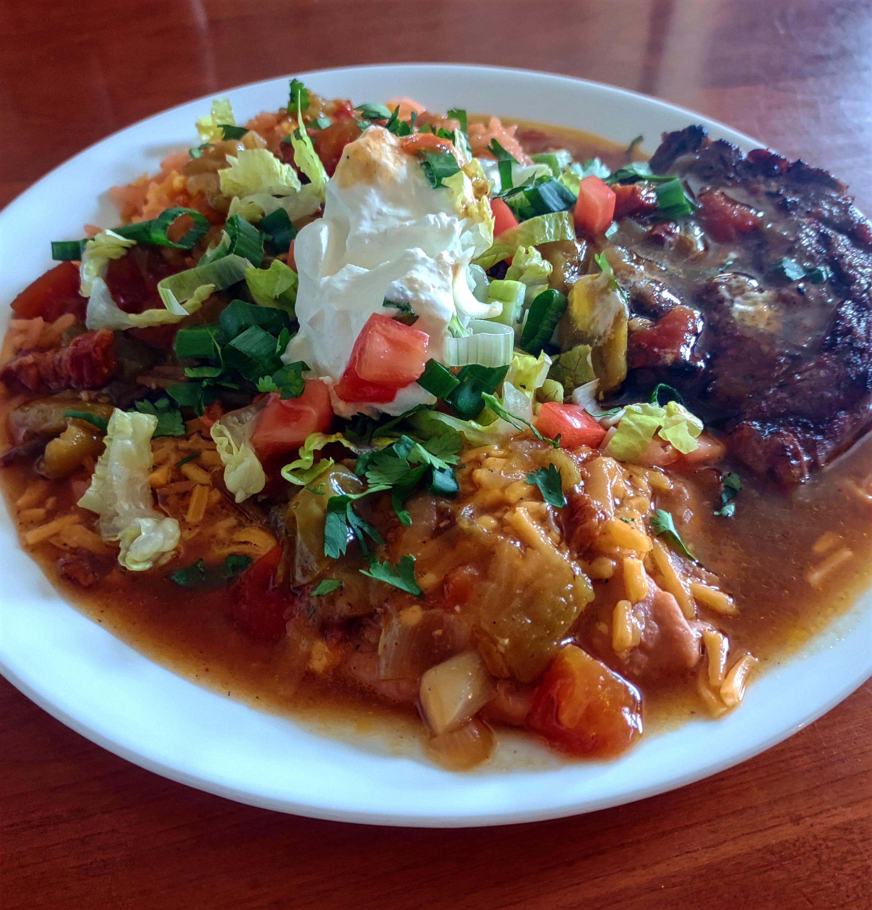 Ribeye steak, red rice, and refried beans all smothered in some ...