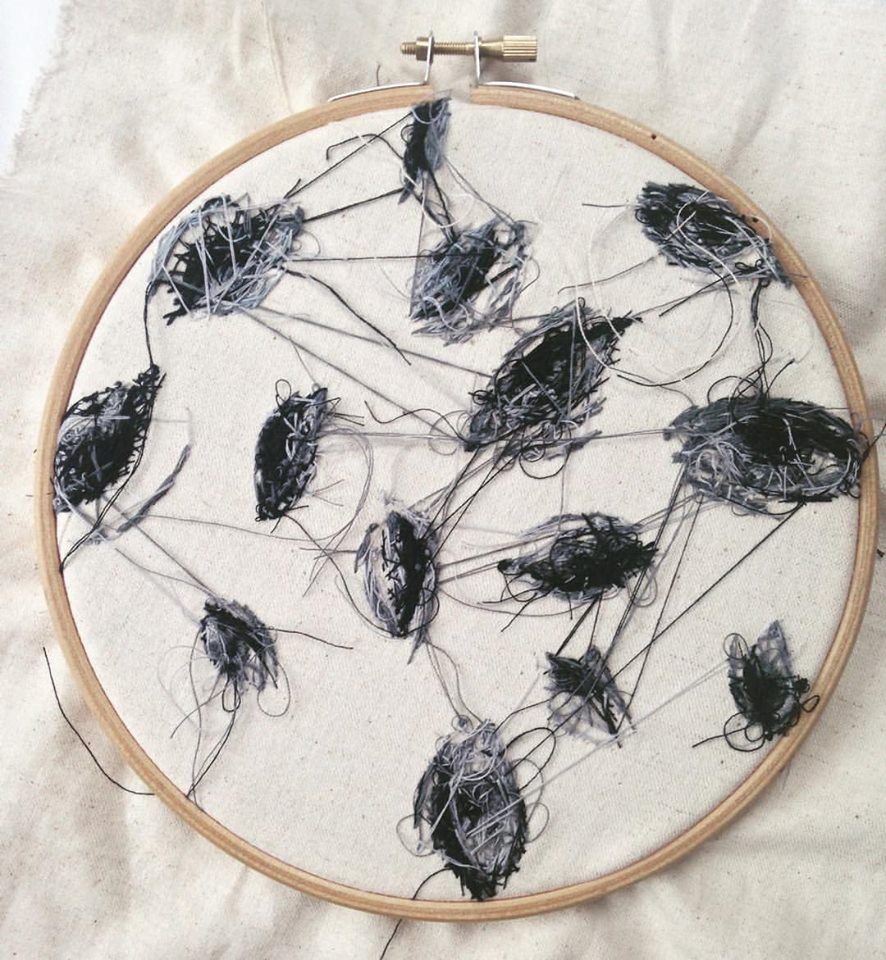 The messy back of a completed embroidery. Scrolller