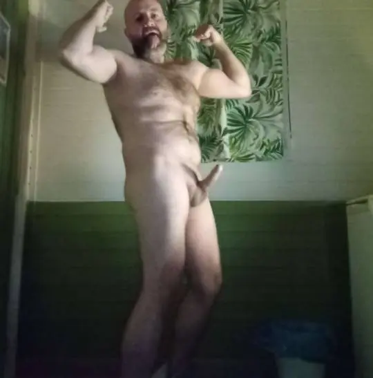 Muscular bald white man craigharding85 flexing naked and sticking out his tongue in a selfie