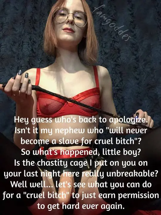 Redhead mistress in red lace lingerie and glasses holding a whip against a blue curtain.