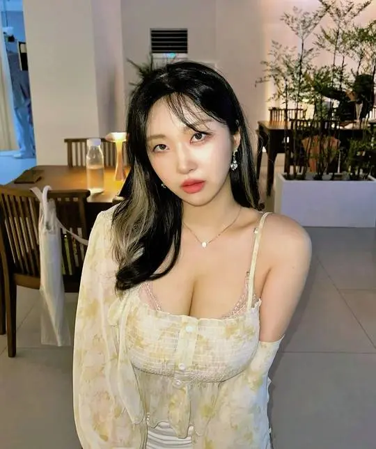 Busty Korean woman in a yellow floral print lace top blouse posing indoors