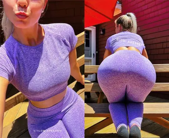 Curvy blonde woman in a purple cropped top and leggings posing on a wooden deck