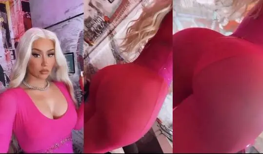 Iggy wearing a tight pink low-cut dress and silver necklace