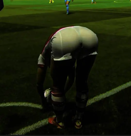 Katie McCabe in a white and red soccer uniform with black leggings and striped over-knee socks on a green field