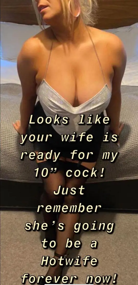 Busty blonde hotwife in a silver halter top and black skirt posing in a bedroom with a caption.