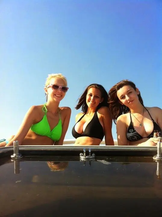 Amanda Ann and a blonde friend in bikinis posing with a monkey in a tropical setting