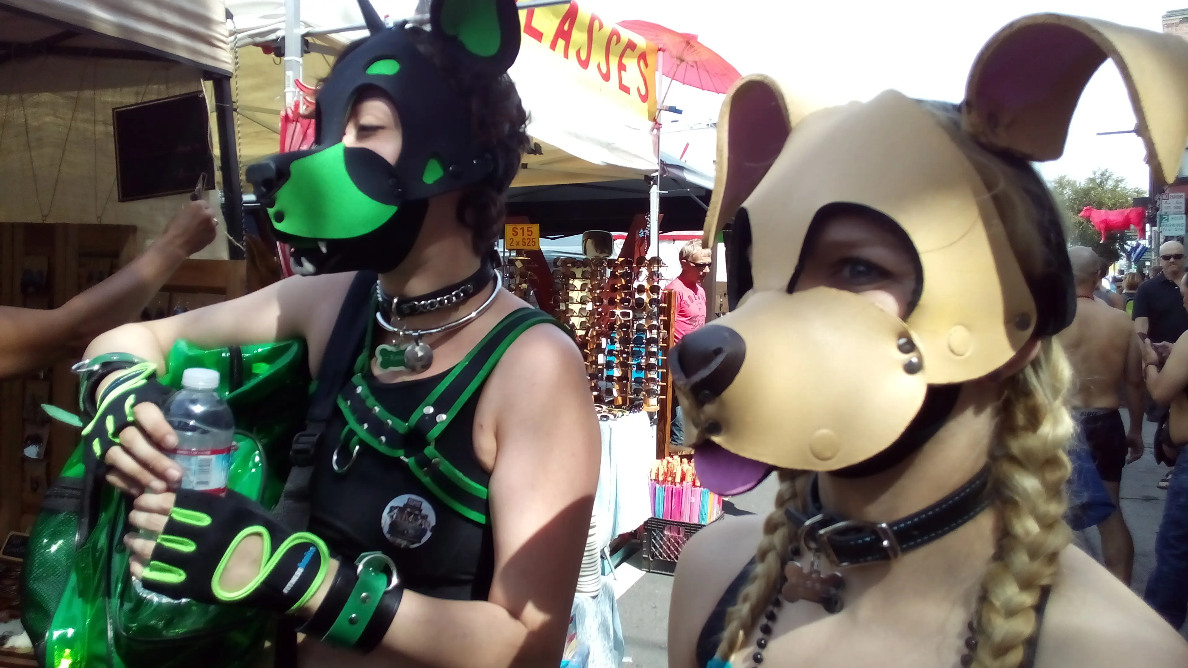 Kato and Pepper in pup play gear and masks at the Folsom Street Fair, including a man in a tiger costume.