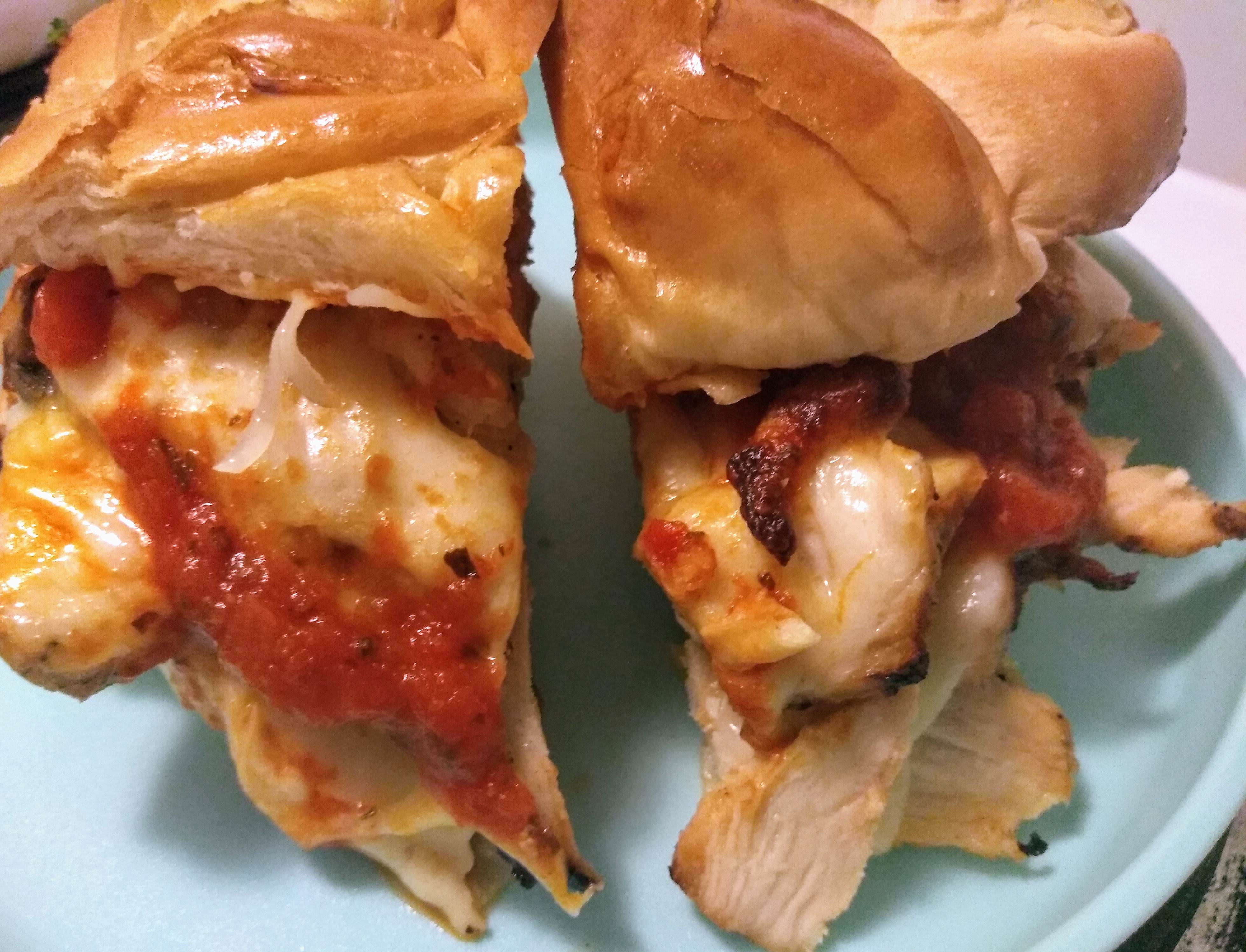 Grilled chicken parm with provolone, hot honey, and fresh basil on challah. Scrolller