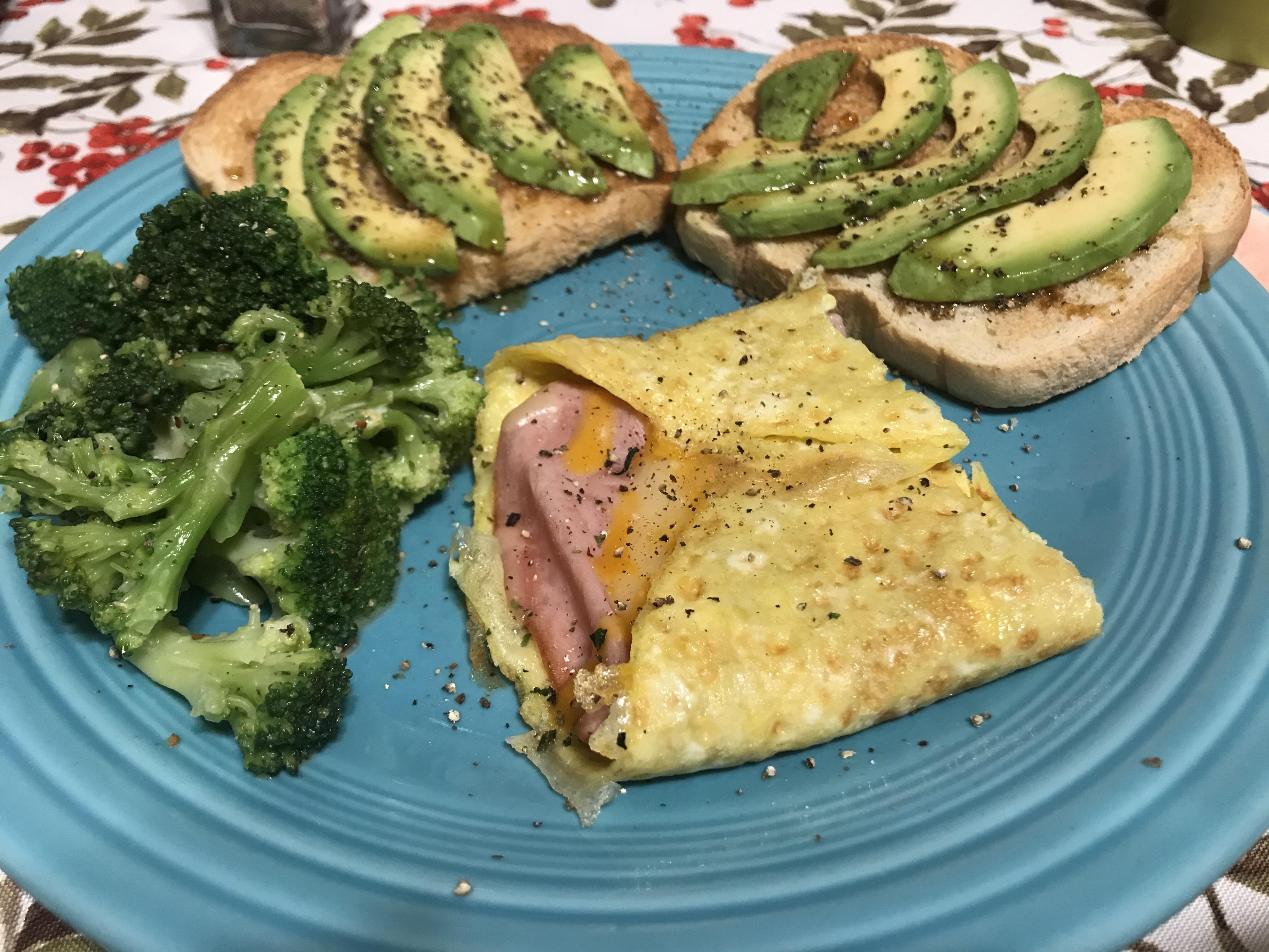 Half a ham and cheese omelet, avocado toast with wildflower honey