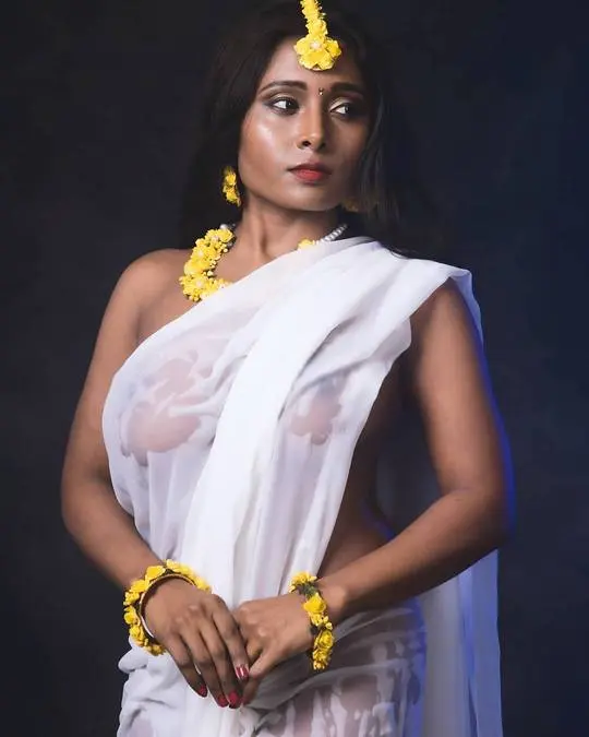 Marathi beauty in a sheer white saree and yellow floral jewelry with a bindi