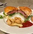 Homemade Burger on the Grill - Cooked Medium Rare served on a Brioche bun with Cheddar, Arugula &amp; Baby Spinach, Red Onion, and Creamy Sriracha