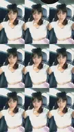 Findom latina woman with brown hair and bangs in a white crop top and pink skirt posing in a car interior.