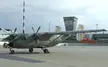 OnlyFans creator with a military transport aircraft on an airport tarmac