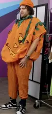 A man in a funny pumpkin costume with an orange tunic, beret, and sneakers for a Smosh meme.