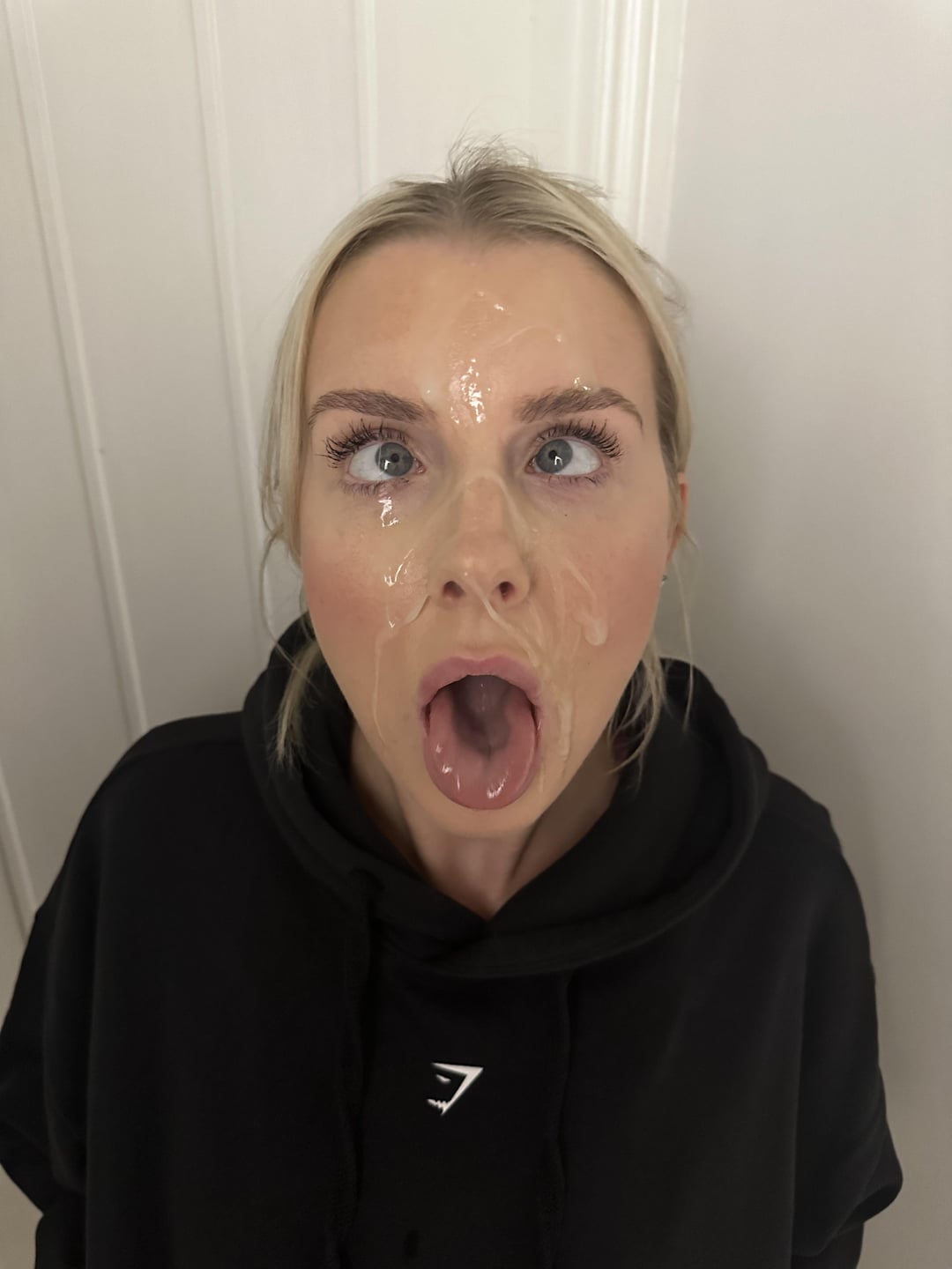 Blonde white woman in a black hoodie with a facial and cum on her face and mouth