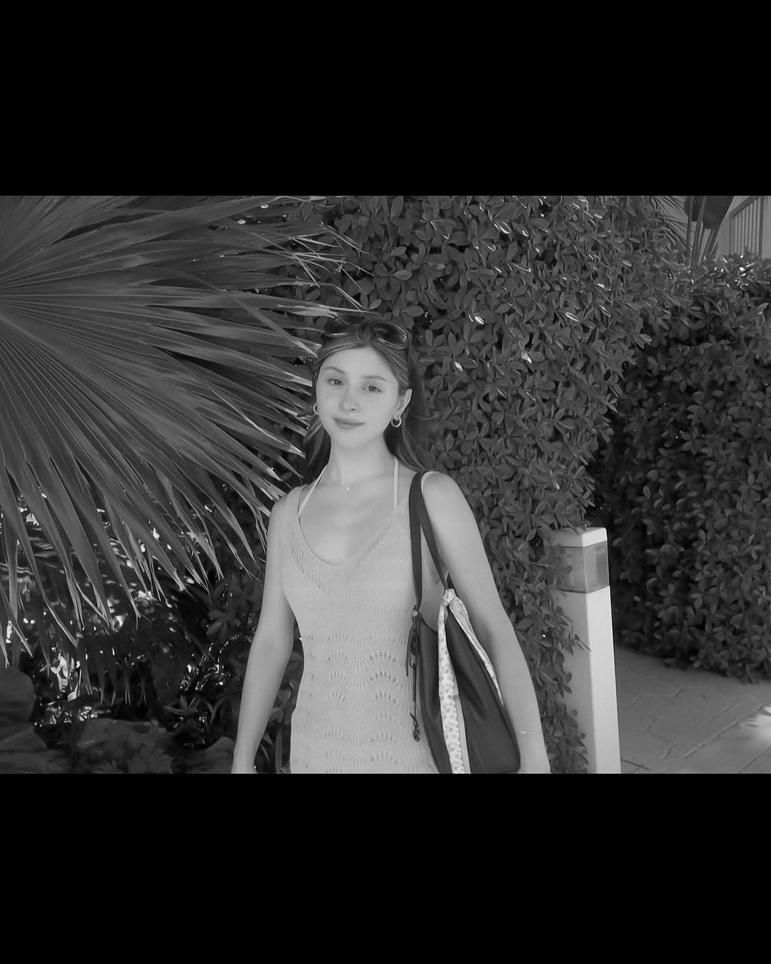 Skye ASMR posing in a sunny garden wearing a white halter top and beige skirt