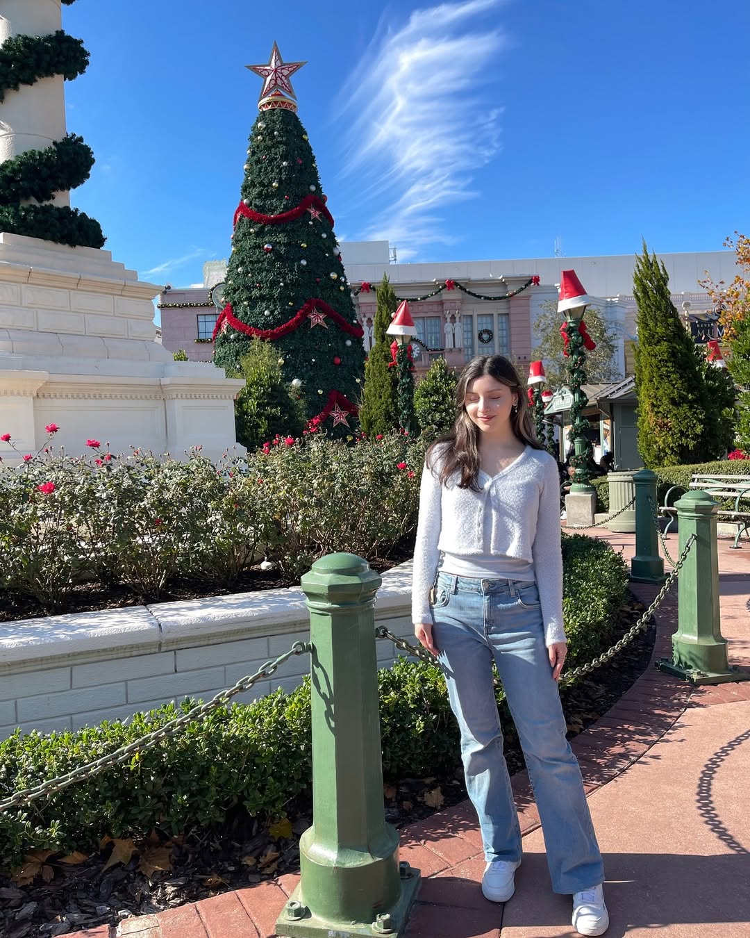 Skye ASMR posing in a sunny garden wearing a white halter top and beige skirt