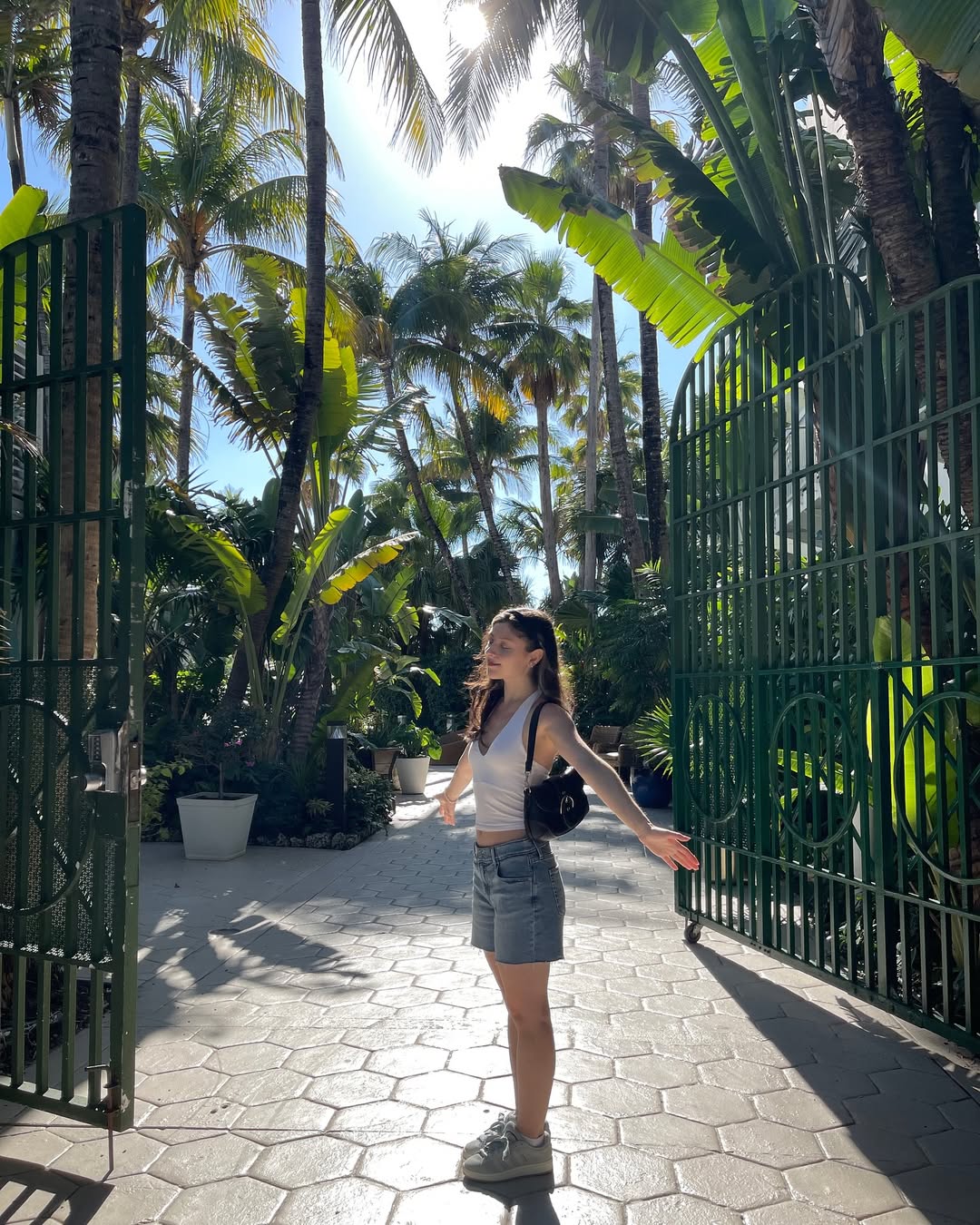 Skye ASMR posing in a sunny garden wearing a white halter top and beige skirt