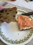 Cursed food: a hand holding raisin bread over a slice topped with cream cheese and smoked salmon.