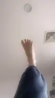 Allie Gonino barefoot with lime green nail polish and dark blue sweatpants moving her foot closer to the camera.