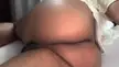 Ebony BBW woman in a white shirt shaking her huge ass and jiggling her thick thighs on a bed
