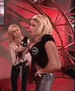 Trish Stratus in a WWE studio performing a panty peel to reveal her black thong.