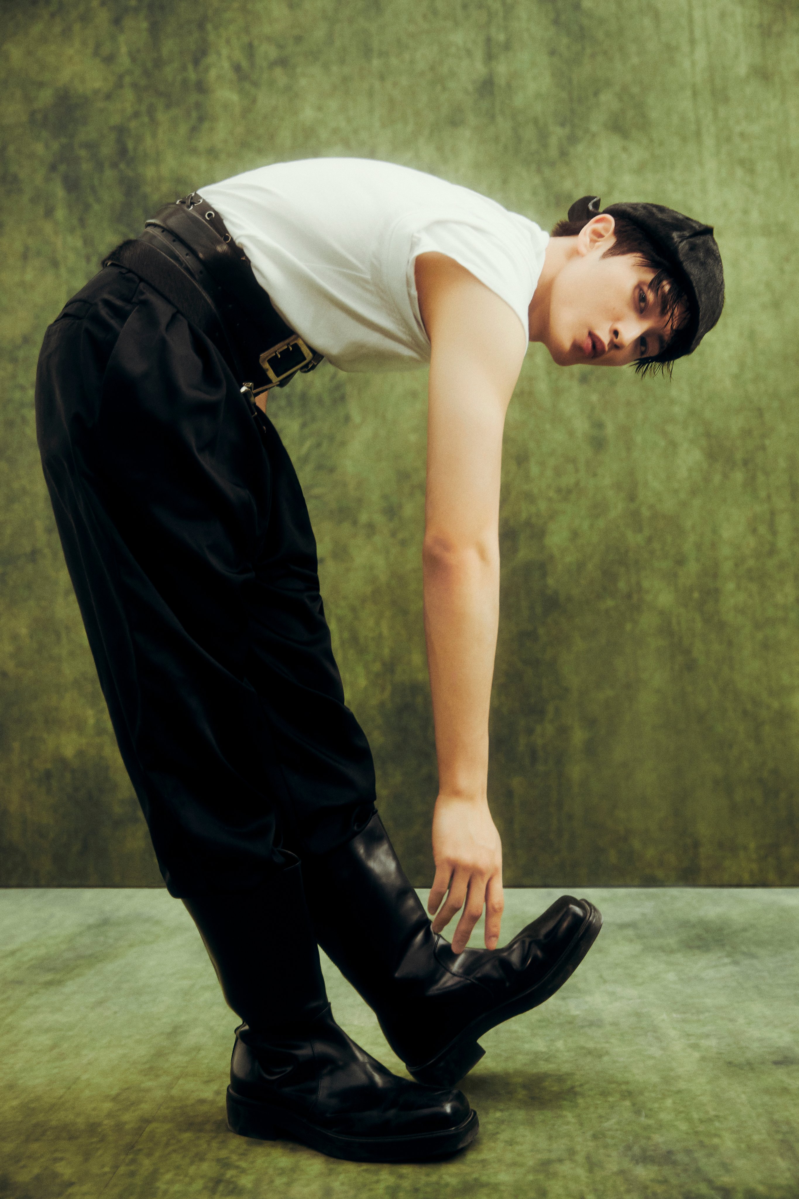 NCT Mark in a white t-shirt, black trousers, and black cap for The Firstfruit teaser