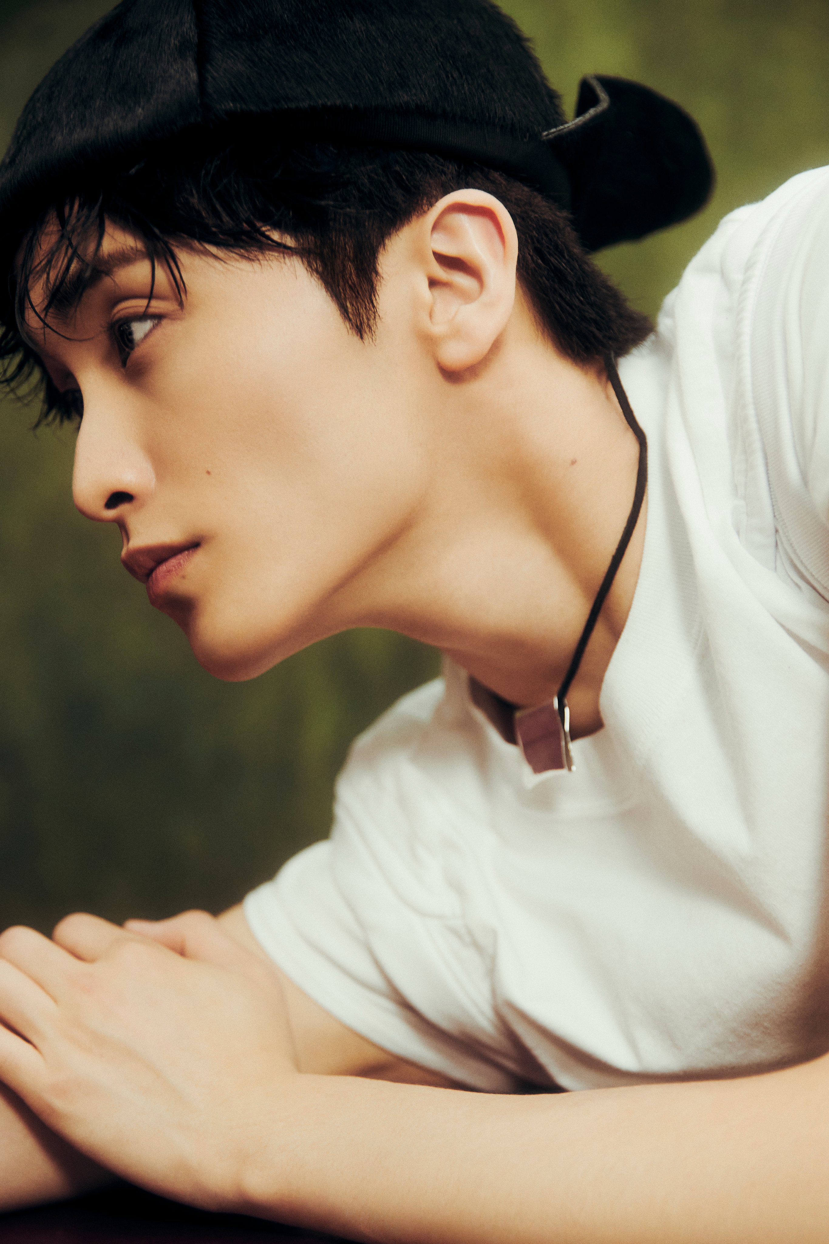 NCT Mark in a white t-shirt, black trousers, and black cap for The Firstfruit teaser