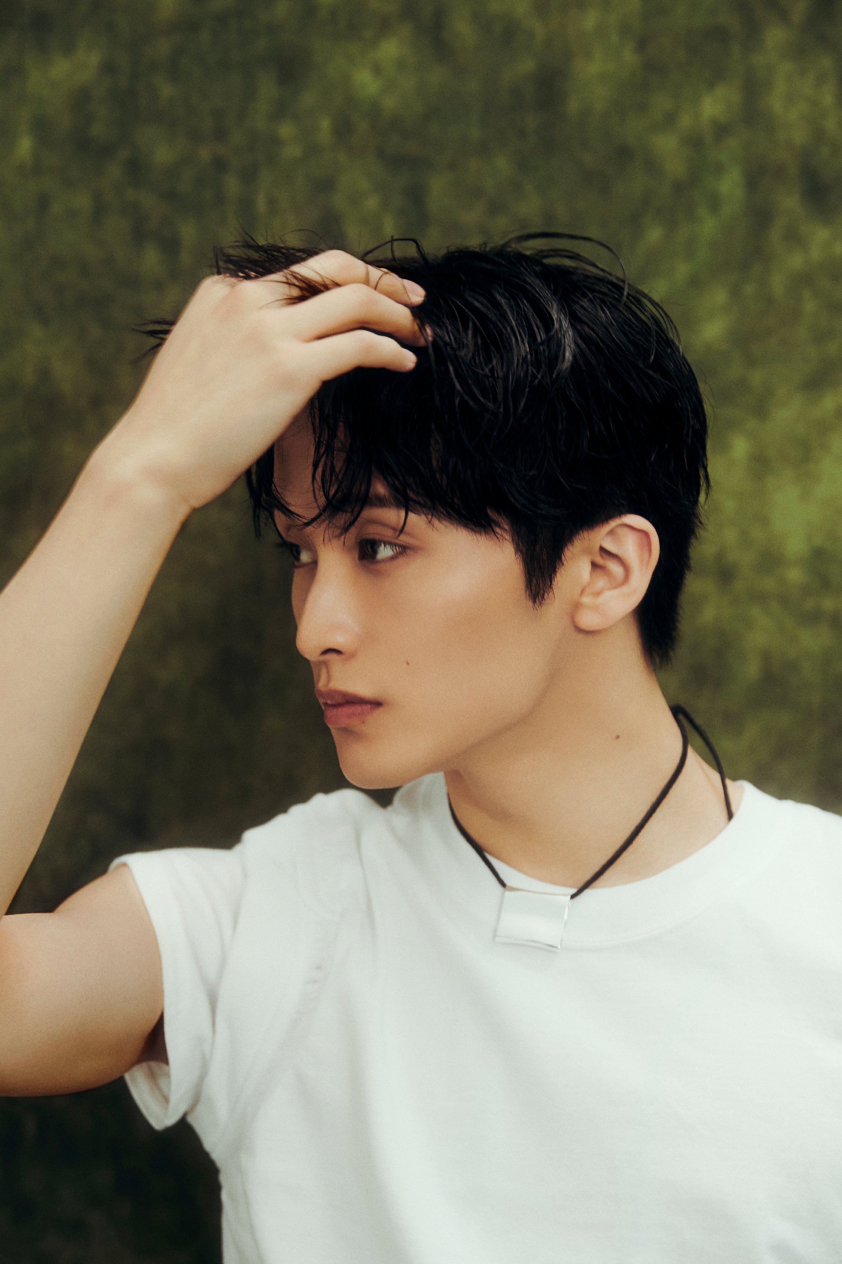 NCT Mark in a white t-shirt, black trousers, and black cap for The Firstfruit teaser