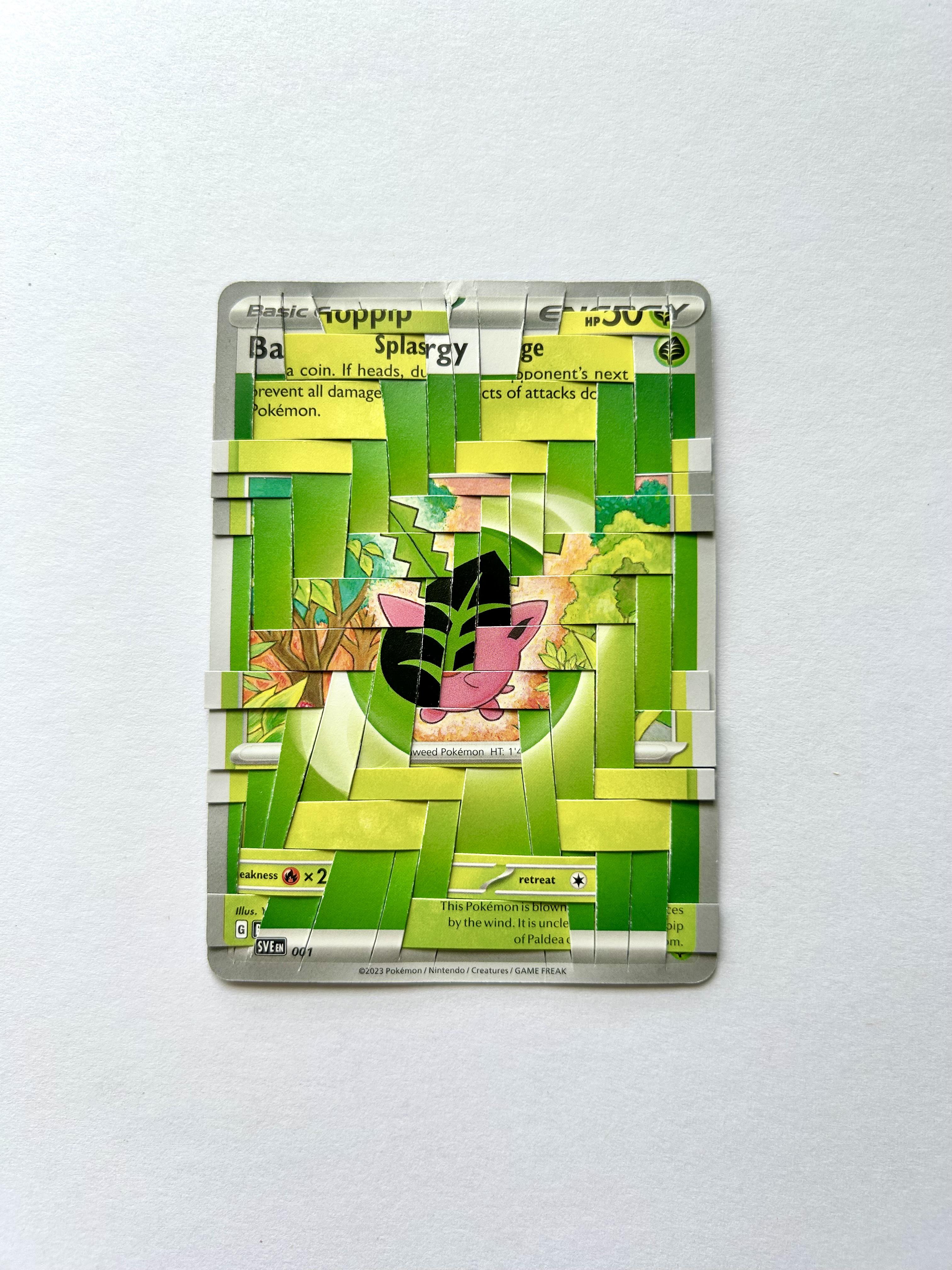 A person with pale skin holding a clear plastic case with a fragmented Pokémon weaving of a Colress Machmer card.