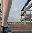 Athletic blonde man in black spandex bending over on a wooden boardwalk to expose his uncut penis and ass.
