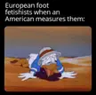 Donald Duck lying flat on his stomach in a desert landscape, looking exhausted and defeated.