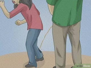 A funny wikiHow comic of a person in a green shirt urinating on Melissa, who wears a red shirt and blue jeans.