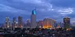 Jakarta, Indonesia city skyline with skyscrapers and residential houses under a cloudy twilight sky