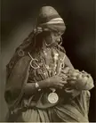 An elaborately jeweled Bedouin mother feeding her baby, 1900s. [1000 x 1280]